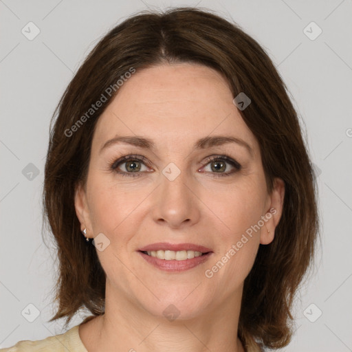 Joyful white adult female with medium  brown hair and green eyes