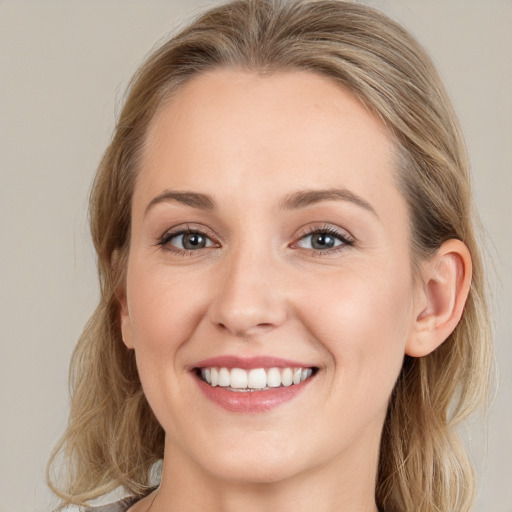 Joyful white young-adult female with long  brown hair and grey eyes