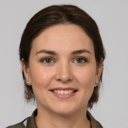 Joyful white young-adult female with medium  brown hair and grey eyes