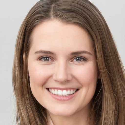 Joyful white young-adult female with long  brown hair and grey eyes