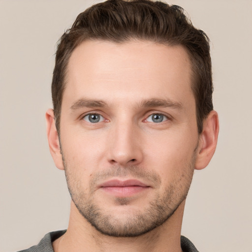 Joyful white young-adult male with short  brown hair and grey eyes