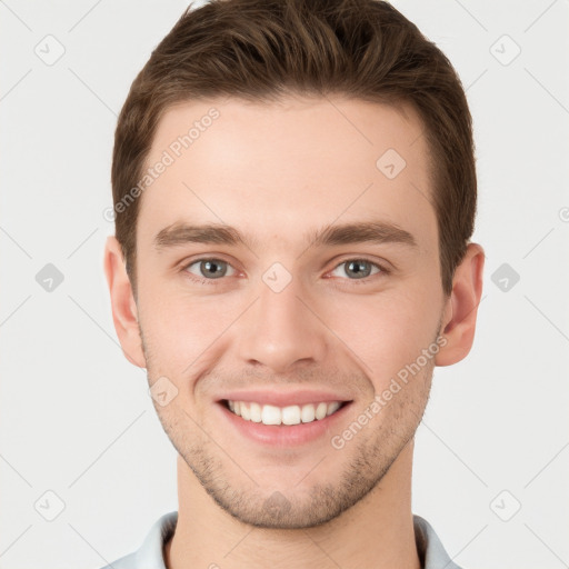 Joyful white young-adult male with short  brown hair and grey eyes