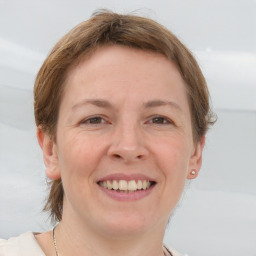 Joyful white adult female with medium  brown hair and grey eyes