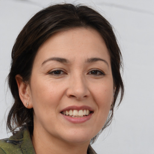 Joyful white adult female with medium  brown hair and brown eyes