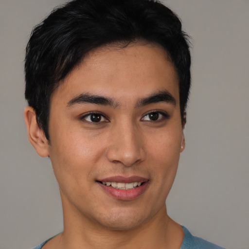 Joyful latino young-adult male with short  brown hair and brown eyes