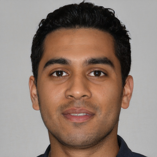 Joyful latino young-adult male with short  black hair and brown eyes