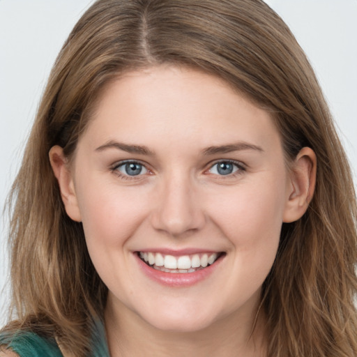 Joyful white young-adult female with long  brown hair and grey eyes