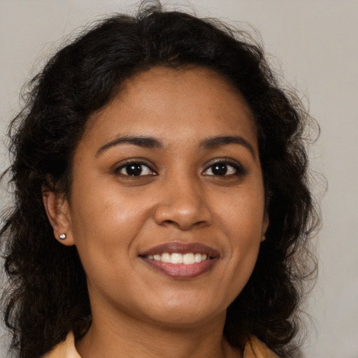 Joyful black young-adult female with long  brown hair and brown eyes