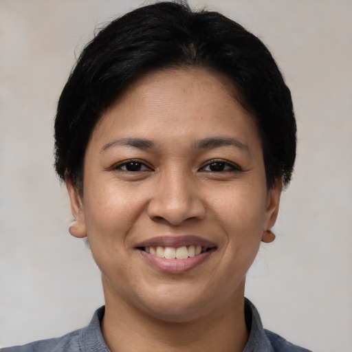 Joyful latino young-adult female with short  black hair and brown eyes