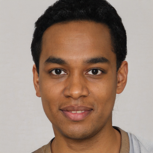 Joyful black young-adult male with short  black hair and brown eyes