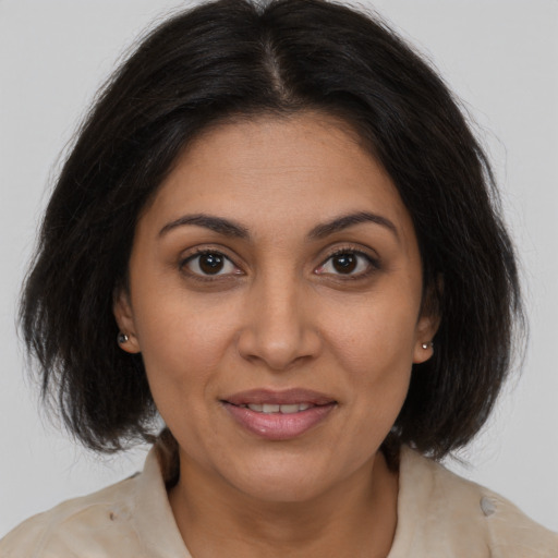 Joyful latino adult female with medium  brown hair and brown eyes