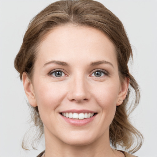 Joyful white young-adult female with medium  brown hair and grey eyes