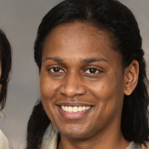Joyful black adult female with medium  brown hair and brown eyes