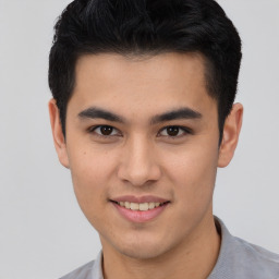 Joyful asian young-adult male with short  black hair and brown eyes