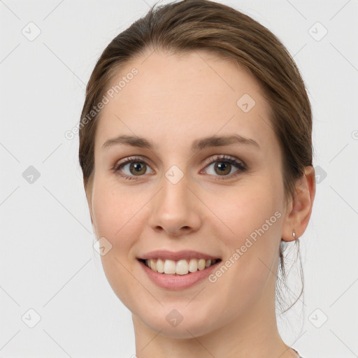 Joyful white young-adult female with medium  brown hair and grey eyes