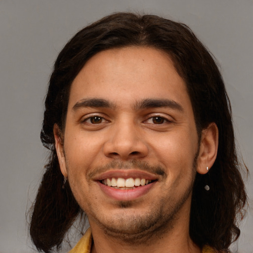 Joyful white young-adult male with long  brown hair and brown eyes