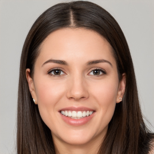 Joyful white young-adult female with long  brown hair and brown eyes