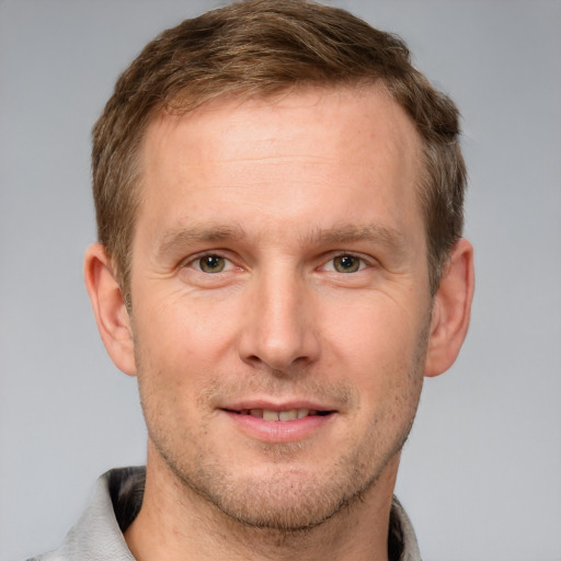 Joyful white adult male with short  brown hair and grey eyes