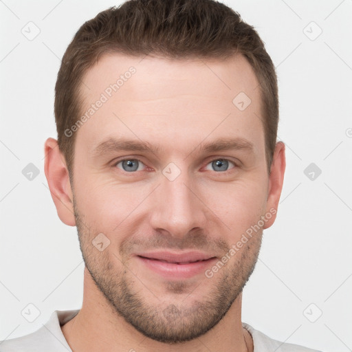 Joyful white young-adult male with short  brown hair and grey eyes