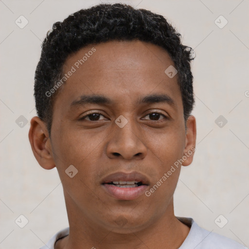 Joyful black young-adult male with short  brown hair and brown eyes