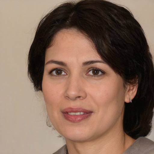 Joyful white adult female with medium  brown hair and brown eyes