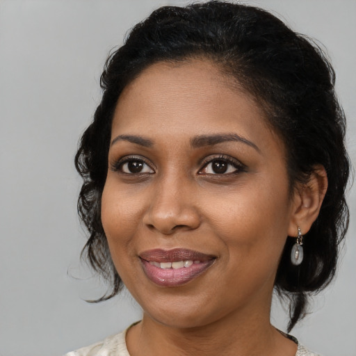 Joyful black young-adult female with medium  brown hair and brown eyes
