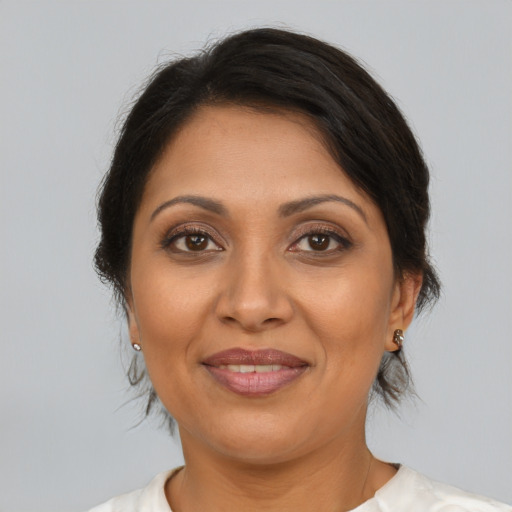 Joyful latino adult female with medium  brown hair and brown eyes