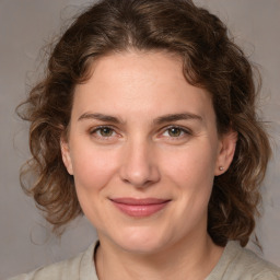 Joyful white young-adult female with medium  brown hair and blue eyes