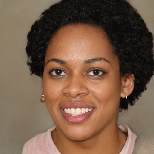 Joyful black young-adult female with short  black hair and brown eyes