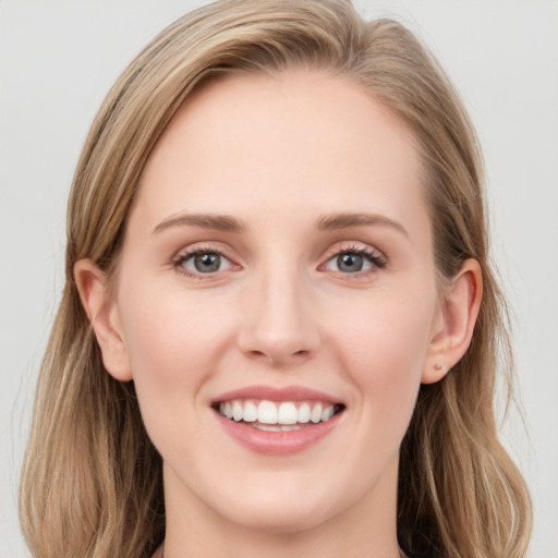 Joyful white young-adult female with long  brown hair and blue eyes