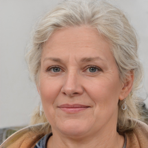 Joyful white middle-aged female with medium  blond hair and brown eyes