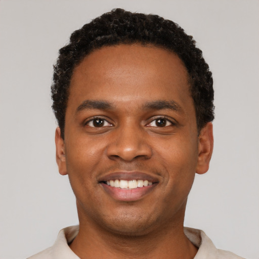 Joyful black young-adult male with short  black hair and brown eyes