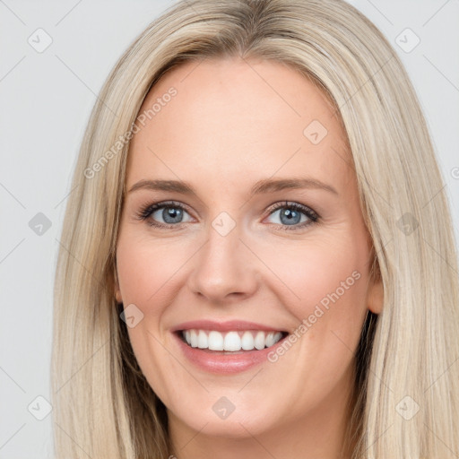 Joyful white young-adult female with long  brown hair and blue eyes