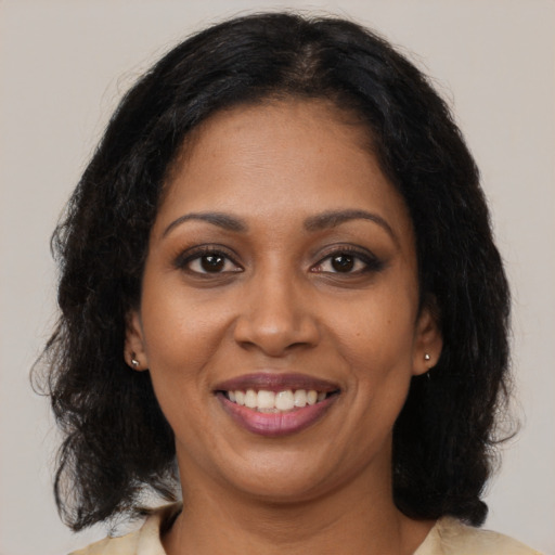 Joyful black young-adult female with medium  brown hair and brown eyes