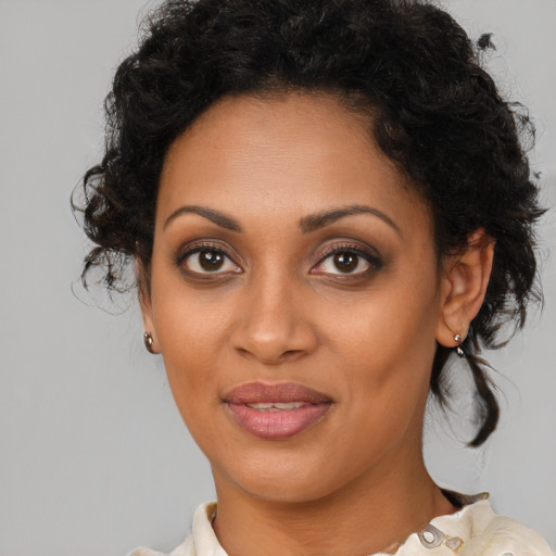 Joyful black young-adult female with medium  brown hair and brown eyes