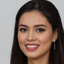 Joyful latino young-adult female with long  brown hair and brown eyes