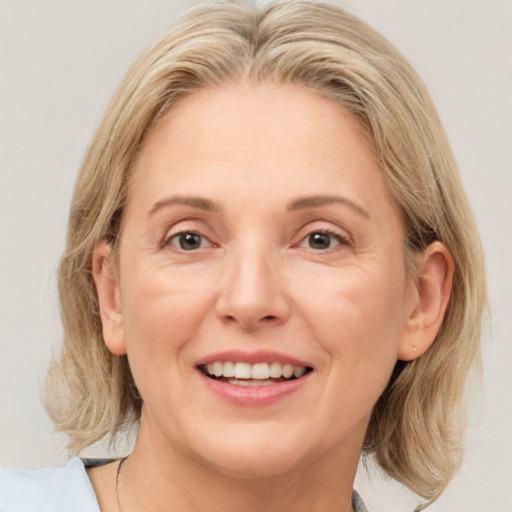 Joyful white adult female with medium  brown hair and blue eyes