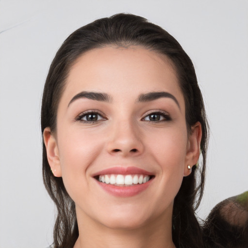 Joyful white young-adult female with long  brown hair and brown eyes