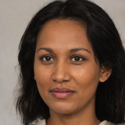 Joyful black adult female with medium  brown hair and brown eyes