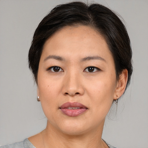 Joyful asian adult female with medium  brown hair and brown eyes