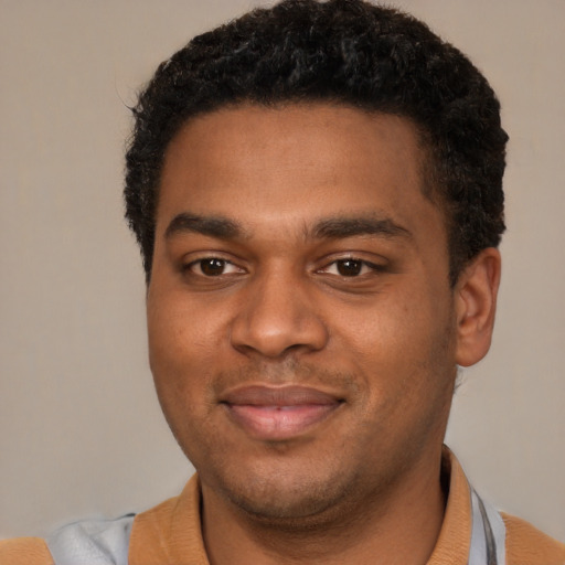Joyful black young-adult male with short  brown hair and brown eyes