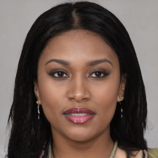 Joyful black young-adult female with long  black hair and brown eyes