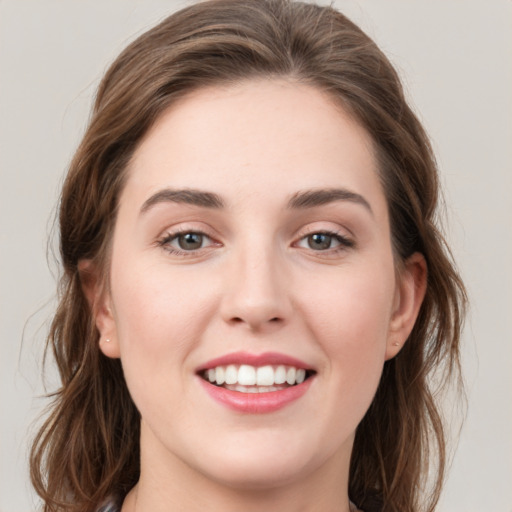 Joyful white young-adult female with medium  brown hair and green eyes