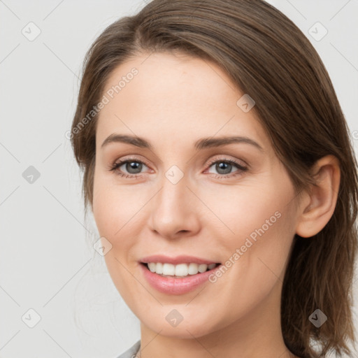 Joyful white young-adult female with medium  brown hair and grey eyes