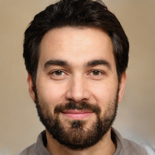 Joyful white young-adult male with short  black hair and brown eyes