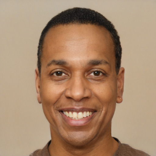 Joyful black adult male with short  black hair and brown eyes