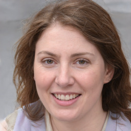 Joyful white adult female with medium  brown hair and blue eyes