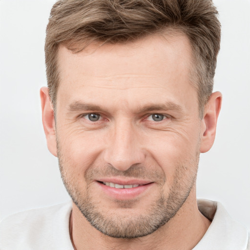 Joyful white adult male with short  brown hair and grey eyes