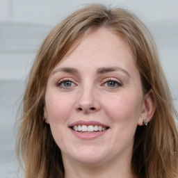 Joyful white young-adult female with long  brown hair and blue eyes