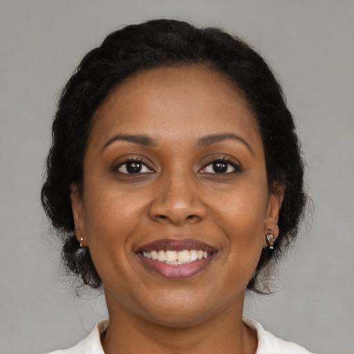 Joyful black adult female with medium  brown hair and brown eyes